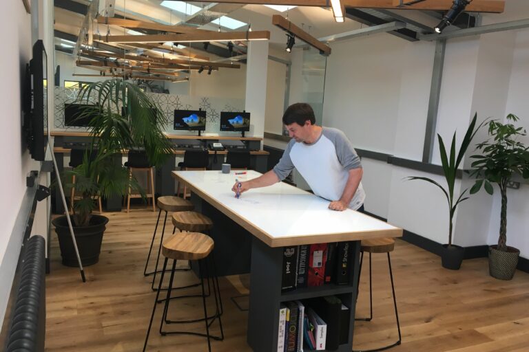 project management image of man drawing on whiteboard desk