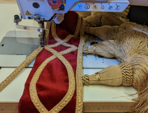 Machine-sewing-braiding-on-bottom-of-wraparound-drape